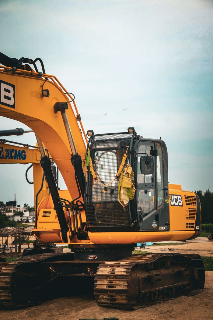 contact-img Yellow excavator at an outdoor construction site on a clear day.